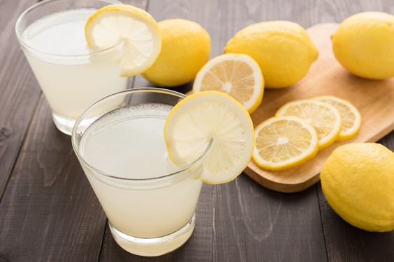 lemonade with fresh slice lemon on wooden table.